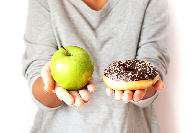 Sund og usund mad - et æble og en donut.