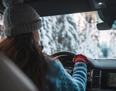 Kvinna kör bil vinter