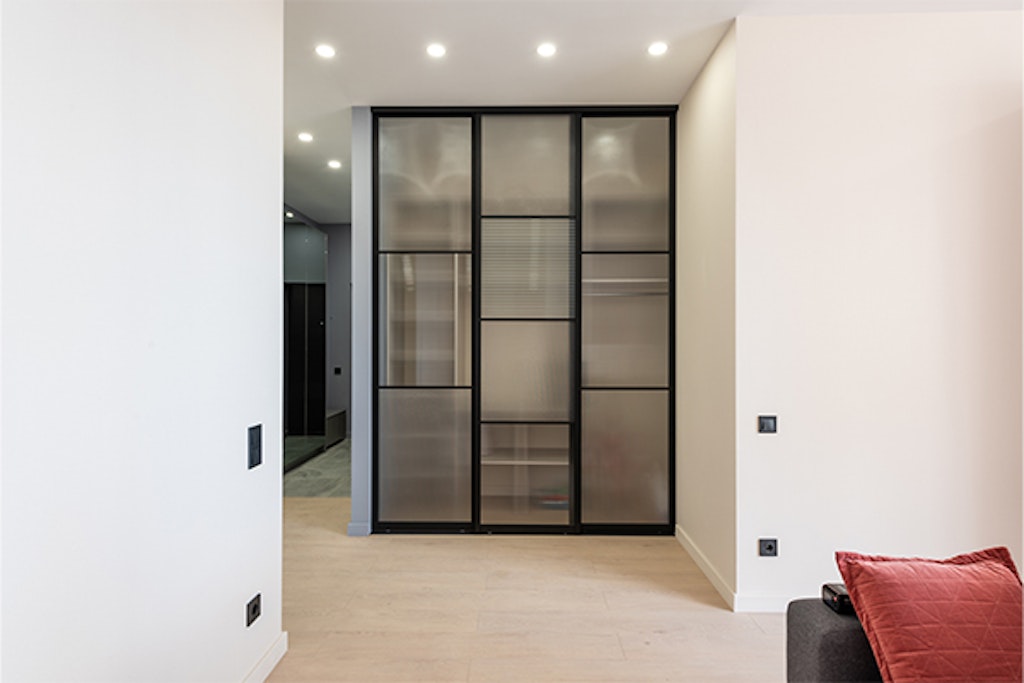 platsbyggd garderob med dörrar av glas