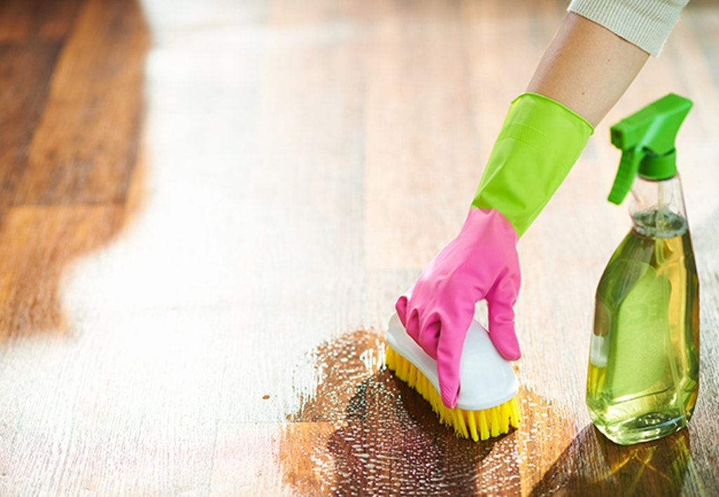 Woman With Cleaning Agent And Brush Wet Cleaning Floor