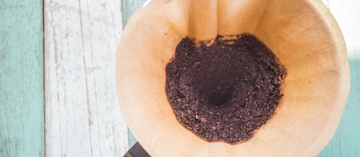 Kaffegrums i kaffefilter på bord