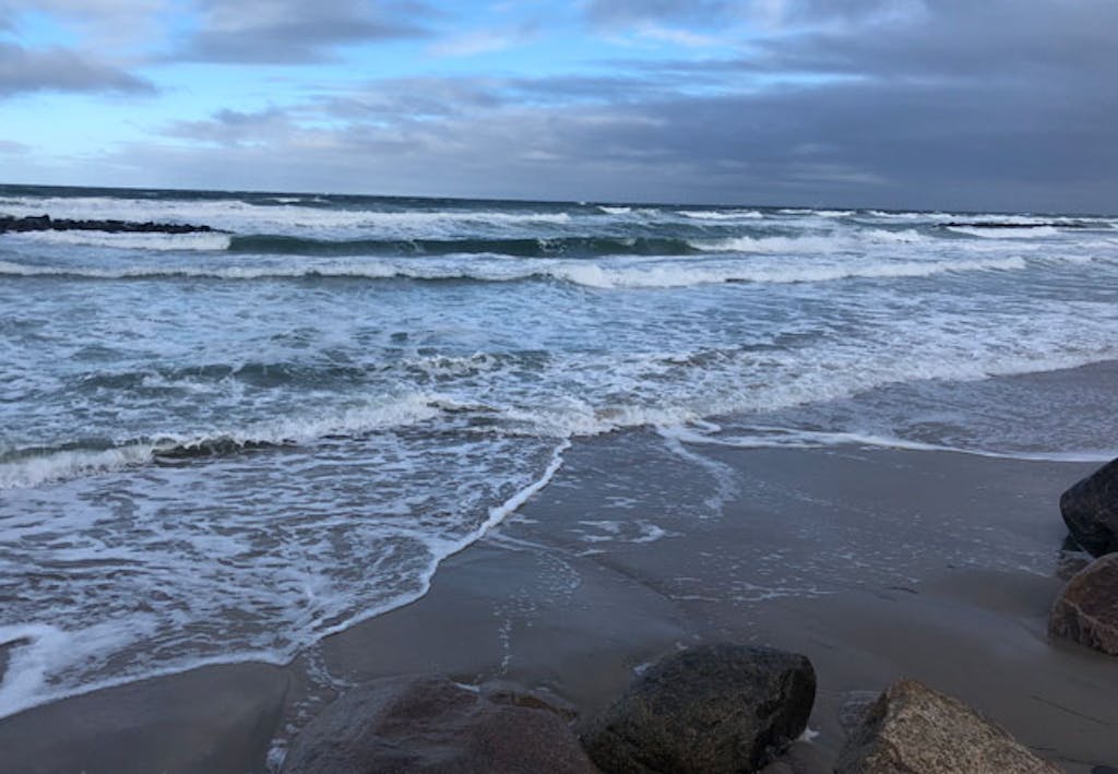 Dansk strandkant med sten og bølger i havet