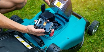 Batteri sættes i elektrisk græsslåmaskine