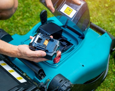 Batteri sættes i elektrisk græsslåmaskine