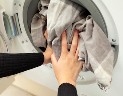 tøj proppes i vaskemaskinen