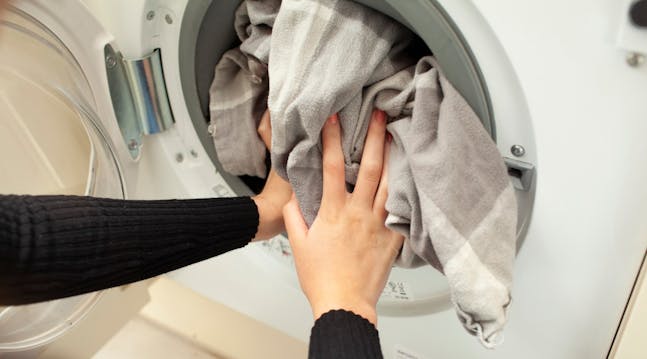 tøj proppes i vaskemaskinen